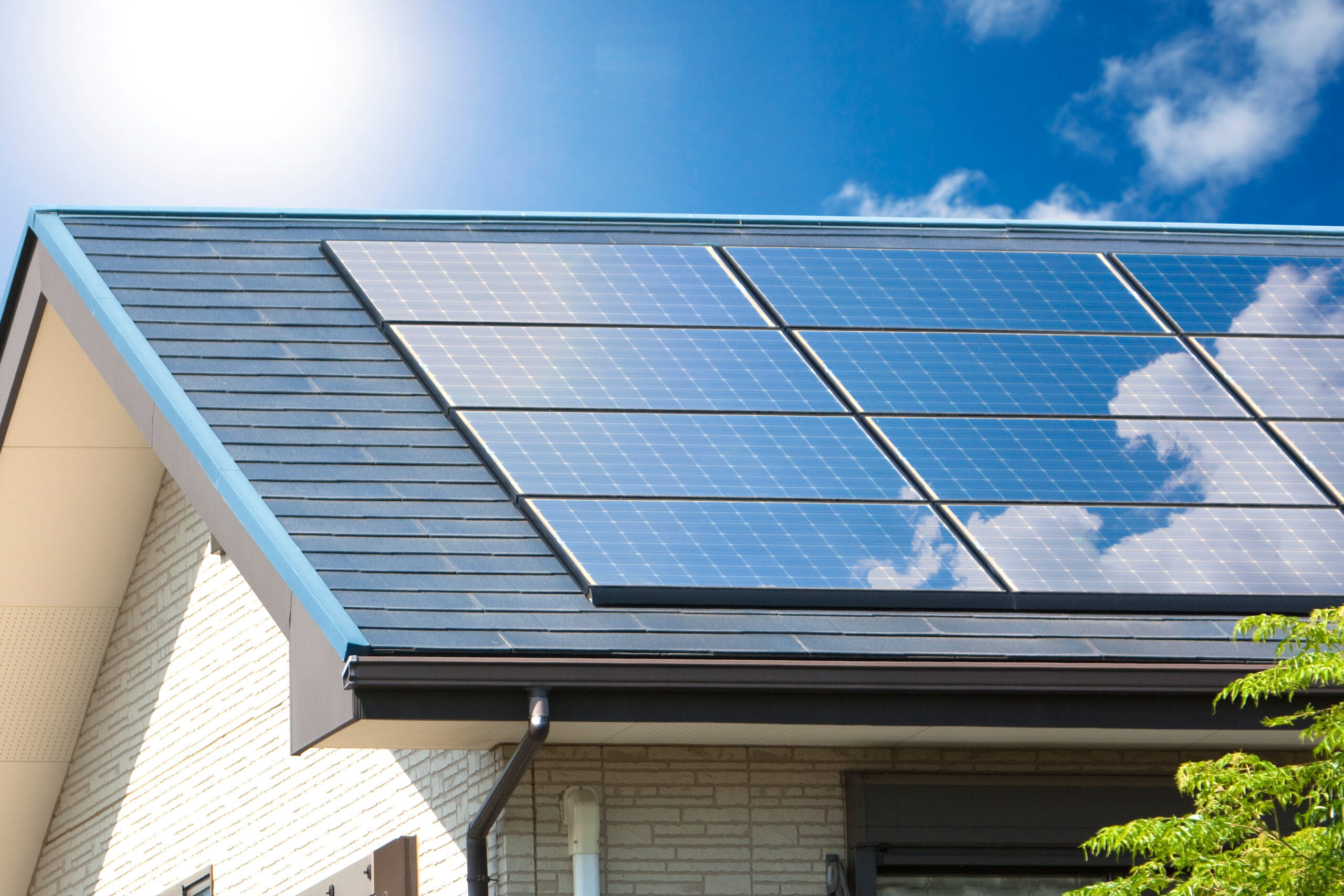 住宅の屋根に設置された太陽光発電設備で発電した電気を売電する仕組みを表現する画像
