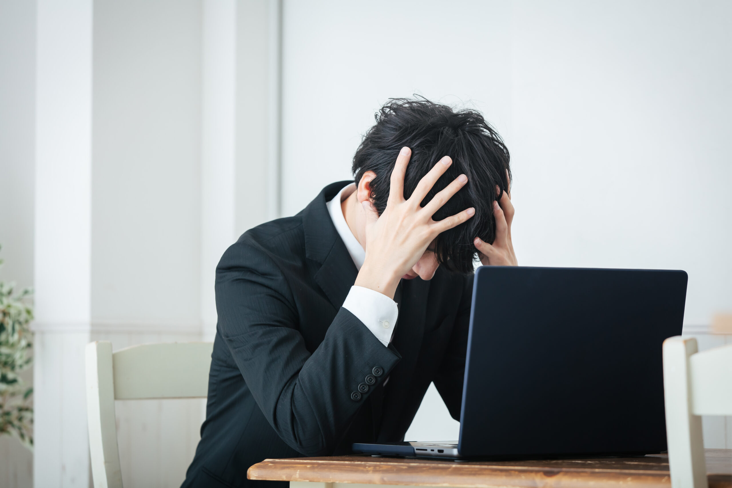申告義務があるのに放置してしまい、頭を抱える会社員を表現する画像