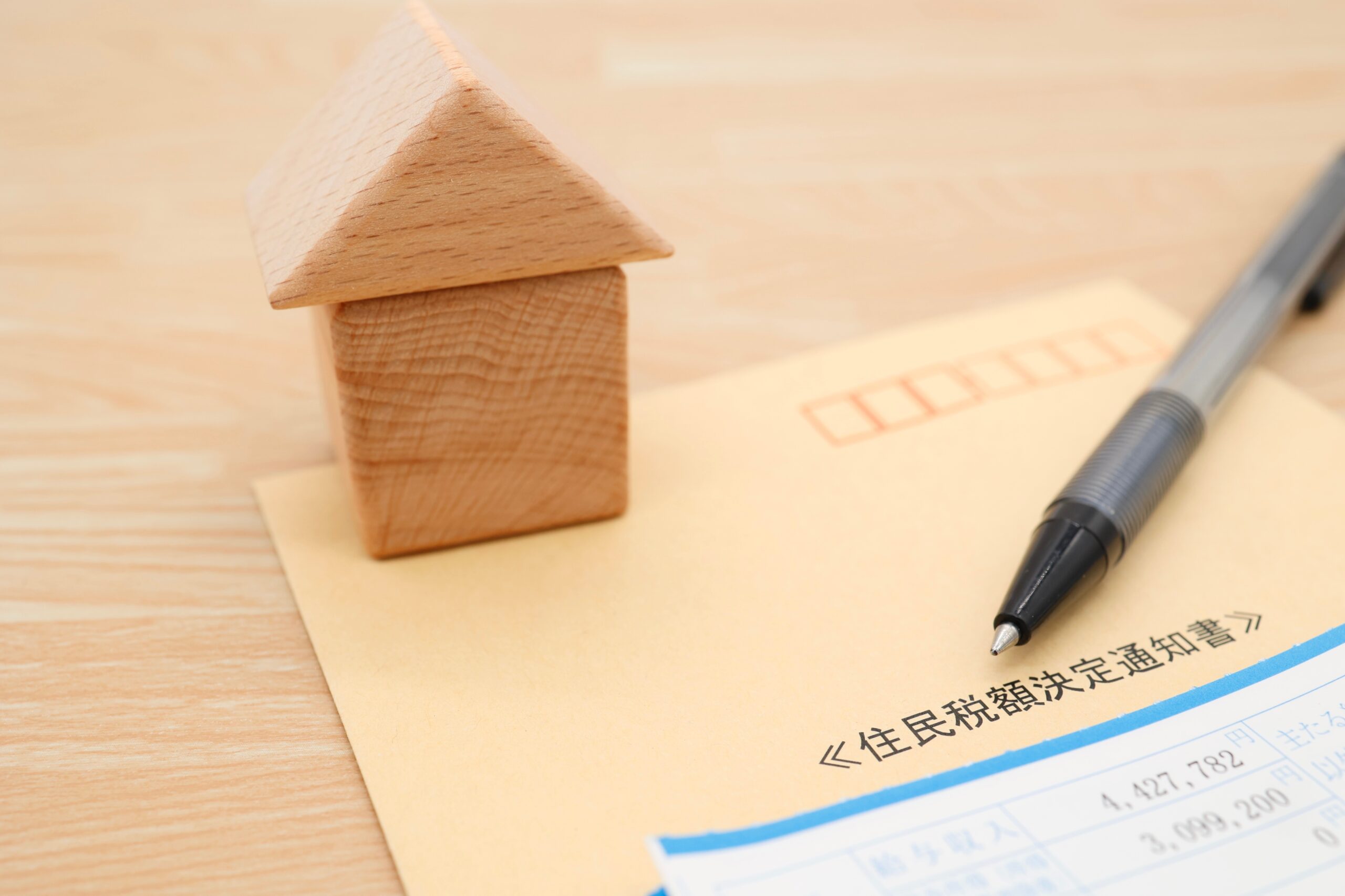 開封した住民税決定通知書を確認する手元を表現する画像
